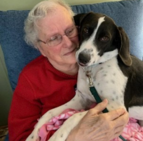 westgate senior homes of the woodlands_elderly woman hugging black and white dog